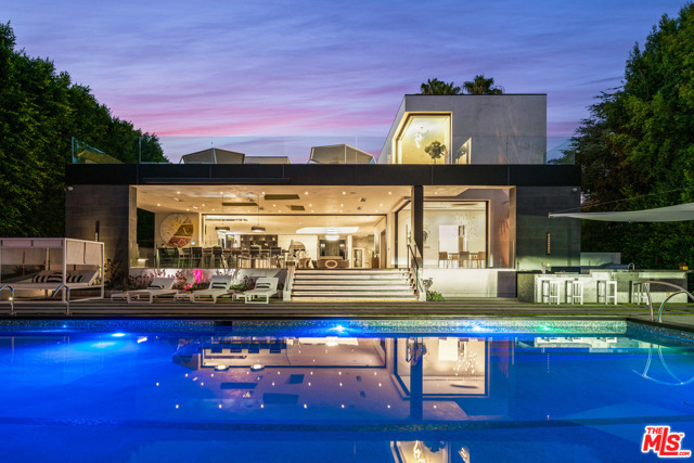 809 N Rexford Drive Beverly Hills, California Rarely does a residence this coveted become available in the Flats of Beverly Hills. 809 Rexford is an unrivaled artistic masterpiece with 6-bedrooms and 9-bathrooms. Arrive via code-key-locked doors to a grand and open living area that seamlessly leads to the outdoor pool area separated by electronic glass sliding doors creating the ultimate indoor-outdoor living experiences. Inlaid marble and rare wood floors invite you to discover elegant spaces made to entertain. Relax in front of the fireplace in the full floor living and dining space, perfect for lavish dinner parties and entertaining. Outside, the massive 13,000 square-foot terrace makes al fresco gatherings irresistible with ambient lighting and gorgeous landscaping. Descend the stunning glass-trimmed staircase to the home's serene private quarters where the movie theater and optional Yoga Studio lay. In the luxurious owner's suite, you'll enjoy a generous footprint for sleeping and sitting areas alongside a wet bar and fireplace. While a customized dressing room with integrated lighting attends to wardrobe needs, his and her bathrooms feature slabs of unique marble providing the ultimate space for rejuvenation.