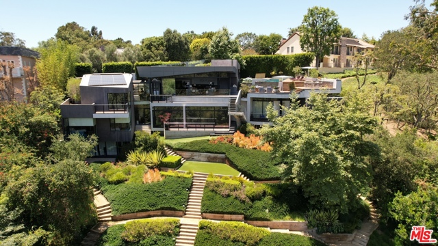 314 N Barrington Avenue Los Angeles, California An exquisitely built architectural masterpiece by Eric Rosen Architects situated in the heart of Brentwood is all about asymmetrical lines. Hidden behind mature landscaping, hedges and gates, the ultra-modern sleek design of simple geometry is thoughtfully done to create comfortable and modern living spaces. The front of the home is almost entirely covered with grass while the backyard is equipped with a pool and a view of the surrounding landscape including the Getty Center. The sliding doors open wide to create a seamless indoor-outdoor flow with an abundance of cascading, light-filled living spaces built into the hillside. Environmentally-conscious and energy efficient design elements were incorporated into the home, including a state-of-the-art geothermal heating & cooling system, a solar powered ion pool, honeycomb radiant floors, and tankless on-demand water heating. With superior hand-selected materials and cutting edge amenities this estate is truly one-of-a-kind.