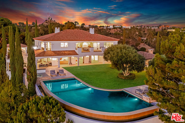 2576 Bowmont Drive Beverly Hills, California Set behind the private gates of Bowmont Estates rests a timeless Mediterranean compound perched atop its own promontory with extraordinary views from the ocean to the canyon. Enter through the grand two-story foyer to the large public rooms, framed in double French doors. The main level features a chefs kitchen, dining room, living room, office and en-suite bedroom with Infrared sauna. Upstairs includes the master suite with two bathrooms, steam showers, dual massive walk-in closets and a sweeping balcony that captures the picturesque sunsets. Additionally, two spacious en-suite bedrooms. The guesthouse features an en-suite bedroom, kitchenette with living room and gym. Adjacent, an entertainment wing with a home theatre, and a bar that flows into a wine tasting room idyllic for entertainment. The grounds include vast terraces, an outdoor kitchen and dining pavilion, a lush grass lawn and a wraparound infinity pool and spa floating above its surroundings. Truly a unique setting.