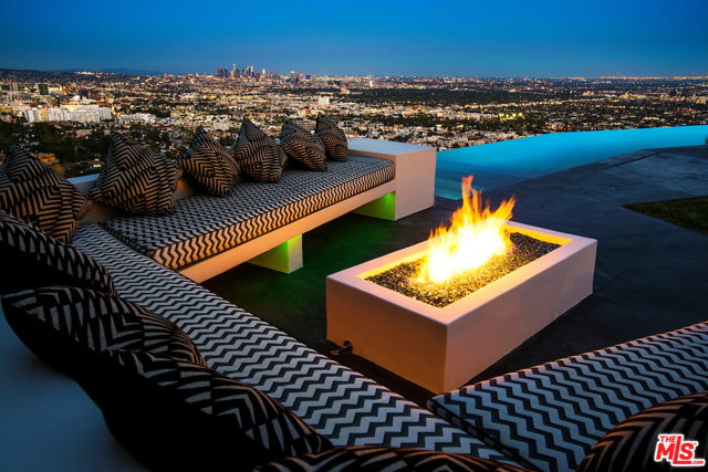 2002 Hercules Drive Los Angeles, California Gated and ultra-private warm contemporary with one of the most explosive and unobstructed views of downtown LA and beyond. Moments from the SunsetStrip, this property features floor to ceiling walls of Fleetwood pocket glass doors opening to an extensive backyard, featuring a 65' stunning infinity pool that spills into thesexy downtown views. A firepit lounge, outdoor bar, outdoor kitchen and a barbecue kitchen creating the perfect outdoor scene with yard; covered outdoor living, diningareas and an entertainment deck . A bright open floorplan with a fabulous custom chef's kitchen, Italian Cabinetry and top-of-the-line appliances open to the family roomand endless city views. Fantastic living and dining rooms, lavish master suite with office and stunning views with large deck and store size designer closet room. Finishedwith the finest materials. No expenses spared while creating an owner's dream home. Motor court for 9 cars plus 3-car garage.