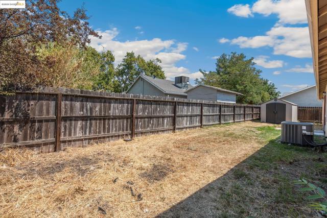 Fenced backyard with a storage shed
