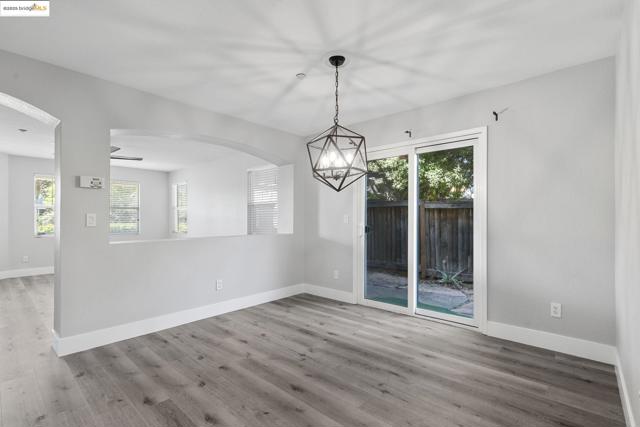Unfurnished dining area featuring plenty of natural light, wood finished floors, arched walkways, and ceiling fan