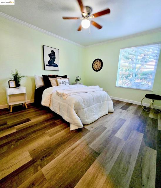 Bedroom featuring ornamental molding, ceiling fan, and wood finished floors