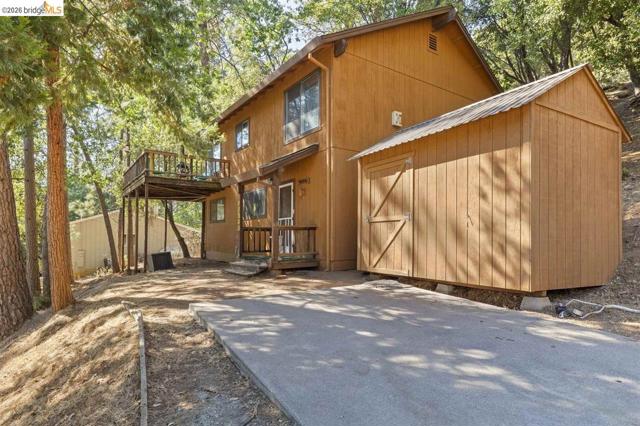Back of property with an outdoor structure and a deck