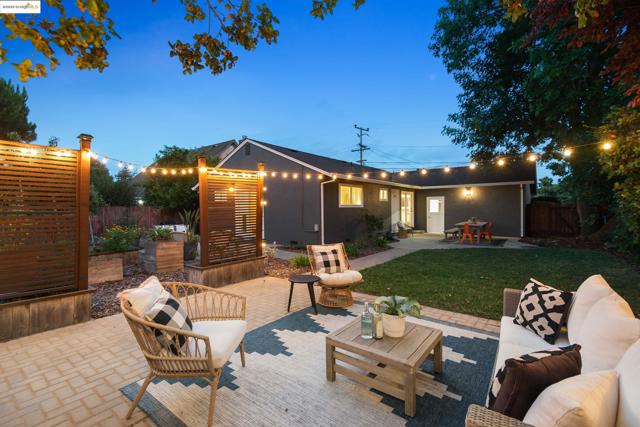 Back of property at dusk featuring a patio area and an outdoor hangout area
