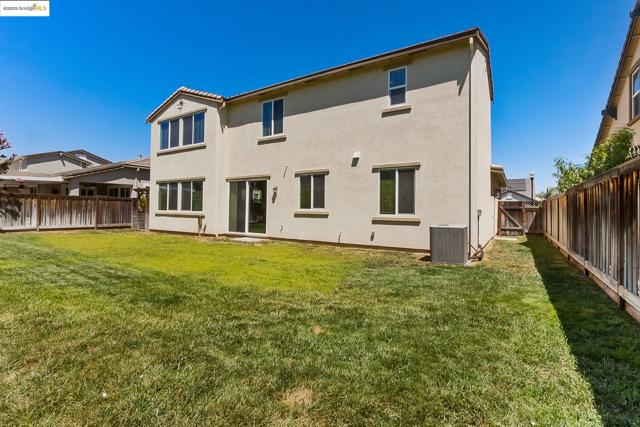 Rear view of house featuring stucco siding and a fenced backyard