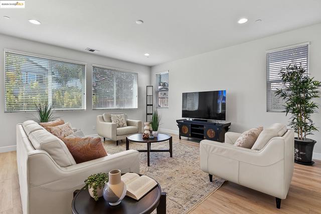 Living area with plenty of natural light, light wood-style floors, and recessed lighting