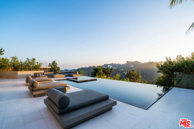 Situated atop Mount Olympus in Hollywood hills, this eloquent estate is one-of-a-kind. Jetliner views of the city take your breath away as the sun sets and the city lights up. Everything your dream home would be becomes reality here. A movie theatre, gym, Infinity pool that flows over a seemingly endless edge, 4 bedrooms, and 5 bathrooms makes this a perfect living situation for a family, or the ultimate bachelor pad. Cozy, yet modern and elegant colors of grey, black and white spiral throughout the home. If views are a must for your clients criteria then there really is no other home for you.