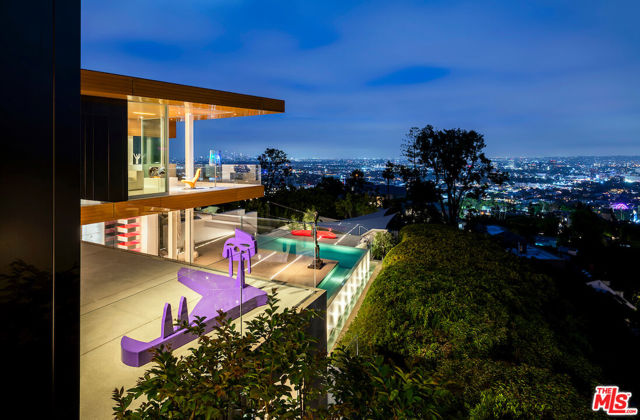 1430 Sunset Plaza Drive Los Angeles, California Acclaimed by Architectural Digest as a "sensational setting," this Sunset Plaza residence has paired the works of McRitchie Design & Gary Hutton Design, resulting in a steel-clad facade that gives way to a gallery-like simplicity infused with a warm ambiance. Gleaming terrazzo floors, architectural lighting, and disappearing walls of glass showcase not only the home's impressive artwork, but also the astounding views from downtown to the ocean. An open floor plan encompasses the clean-lined kitchen and main living/dining areas, all with direct access to the expansive sundeck, taking in the unobstructed views and custom mosaic tiled pool. The primary suite sits wrapped in glass atop the residence, maximizing the outlook, while three secondary bedrooms, a plush media room, and another private outdoor deck complete the level. At the lower level, a substantial covered deck opens to a boutique gallery, offering an ideal space for gatherings of all sizes. This distinctive home is crafted to showcase art of all proportions, the interior walls have plywood inserts to support hanging, while radiant heated floors, a top-tier home security system, elevator and smart home technology round-out the home's elevated features.