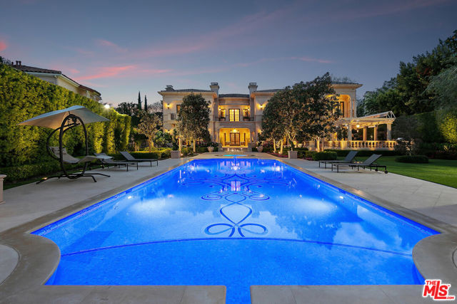 This Italian-inspired mansion in Beverly Hills is a true masterpiece of design and craftsmanship by renowned architect Richard Landry. It offers an elegant and lavish lifestyle with indoor-outdoor entertainment. Notable features include exquisite fixtures and finishes, precision water-cut Italian marble inlays, Crestron home system, commercial elevator, and 2 backup generators. The formal spaces include a living room, dining room, family room, office/library, game room with a 400-bottle wine room, and a chef's kitchen with top-of-the-line appliances, NEFF custom cabinets, and a breakfast area. The upper floor has 4 bedroom suites, each with its own foyer, including the primary suite with a marble bath, walk-in closet, and custom closets with NEFF cabinets. The lower level has a full staff suite, audio/video room, storage room, and a subterranean collector's garage for 12+ cars. The beautifully manicured grounds include a 54-foot pool, a raised spa, a gym, fountains, and covered patio seating areas. The estate is fully equipped with Crestron technology for security, communications, comfort, and entertainment. This luxury home has 5 bedrooms and 10 bathrooms, spans 20,422 square feet on 0.75 acres, and blends timeless elegance with modern sophistication.