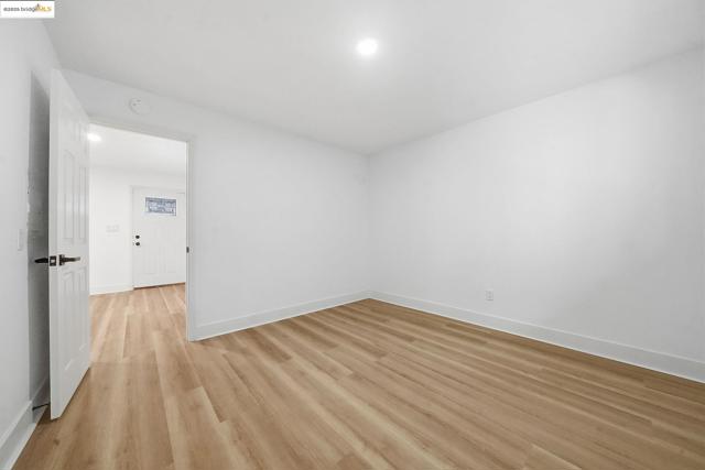 Unfurnished room featuring light wood finished floors and baseboards