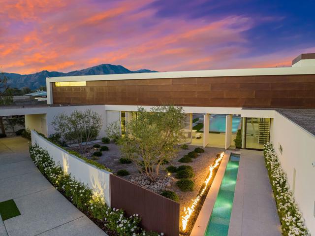 The epitome of Palm Springs chic behind the gates of The Madison Club! This stunning modern home is an architectural masterpiece with walls of glass and a balanced mix of stone, wood, fire and water features. This home showcases the finest finishes, including Wolf, Sub-Zero, Miele appliances as well as marble and quartzite throughout. The primary retreat encompasses the entire second floor, complete with bedroom, indoor/outdoor office, large bathroom with laundry room, covered roof-top deck and elevator. There are two guest rooms on the main level of the home.  Additional amenities include a theatre, temperature-controlled wine room, wet bar, and butler's pantry. A very spacious two-bedroom, two bath casita with living room and kitchen will accommodate your guests in style. The home opens to panoramic views of the golf course and mountains, a sparkling pool with raised spa and BBQ island, perfect for year-round outdoor entertaining.