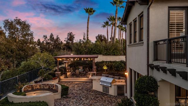 Entertainer’s backyard featuring a built-in BBQ, covered patio with seating, and a cozy fire pit. The perfect outdoor space for dining, relaxation, and gathering under the stars.