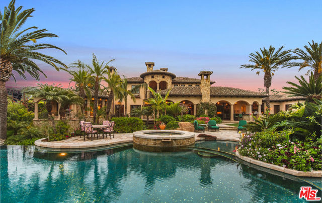 Presenting Villa Monteverde - A timeless blend of Italian elegance and California luxury. Set behind wrought iron gates and framed by mature imported date palms, this extraordinary estate evokes the pages of Architectural Digest. Throughout the property, imported stone elements define the architecture from the grand facade to the tranquil courtyard anchored by an imported Italian fountain and a water feature brought directly from Italy. The landscape is a masterpiece in itself, with petrified wood, flowing fountains, a private orchard, and a stream meandering peacefully through the grounds. Inside, the estate showcases imported Italian materials and masterful craftsmanship at every turn. Venetian plaster walls, imported limestone accents, floors of polished Crema Marfil marble, and hand-scraped walnut wood infuse the home with timeless warmth and sophistication. Several wood-burning fireplaces throughout the estate add ambiance and old-world charm. Groin-vaulted corridors lead to a hand-carved wood ceiling, while grand chandeliers crafted of real crystal descend dramatically at the touch of a button.At the heart of the home, the gourmet kitchen features solid wood cabinetry, a brick-inlaid ceiling, SubZero and Wolf appliances, and striking countertops made from imported Blue Brazilian granite. Retractable pocket doors open to a breathtaking loggia with a fireplace and full outdoor kitchen beneath an imported Italian trellis.Additional highlights include a circular indoor-outdoor bar with a built-in 400-gallon aquarium and a glass floor revealing the wine cellar below. Downstairs, a Renaissance-inspired lounge hosts a 14-person dining table, a 500-bottle wine room, a private amphitheater, and a hidden safe room.The estate is complete with a soundproof home theater, meticulously curated gardens, a detached 785 sq ft guest cottage, and a 7-car garage.Set in one of the most desirable Mediterranean-like climates in California, Villa Monteverde is more than a home it's an immersive, resort-like destination