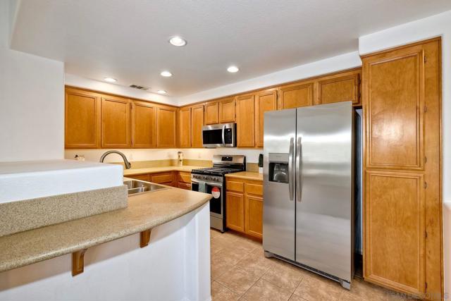 Sleek Corian countertops and a 2-seat breakfast bar in this open, spacious kitchen.