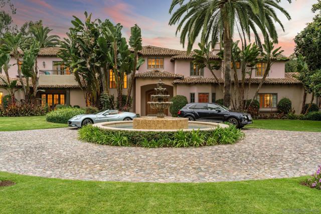 Gorgeous entry courtyard with huge fountain with the cobblestone driveway