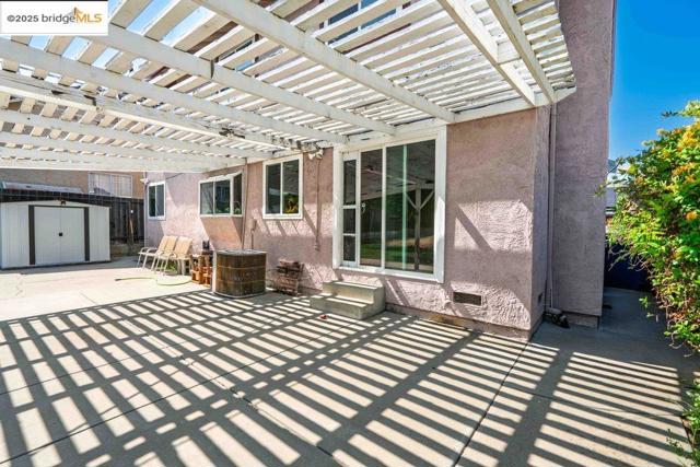 View of patio featuring a storage unit and a pergola