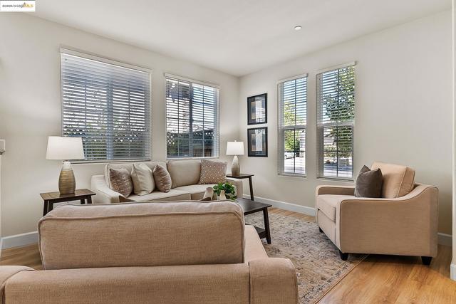 Living room with light wood-style floors and healthy amount of natural light