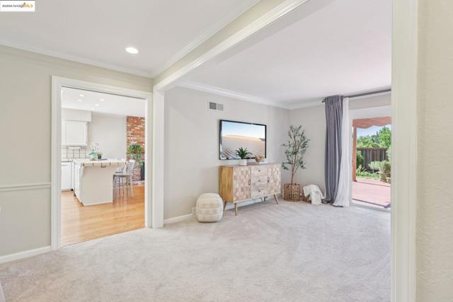 Sitting room featuring light carpet and crown molding