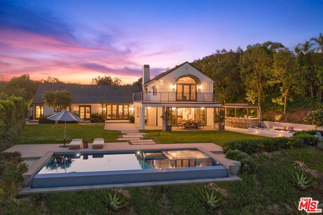 1126 Stradella Road Los Angeles, California Privately situated behind a secured gated motor court entry, this boldly reimagined Traditional residence by the Himes Miller Design Group occupies a class all its own. Positioned on 1.5 acres, the home offers sweeping views of downtown, ridgetops & canyons and Santa Monica Bay. Main level presents European hand scraped white oak floors, private Study, formal sitting and 3 en suite guest or family bedrooms. The primary quarters occupy the top level, featuring large wrap-around terrace with breathtaking vistas, spacious bath, custom walk-in closet and handsome stone clad fireplace. Open kitchen couples with main entertainment room exhibiting exposed wood beams and indoor/outdoor fireplace. Abundant grassy lawn space plus numerous terrace destinations for al fresco dining, outdoor Bar, sunken fire pit, horseshoe court & fruit trees all present beautifully adjacent to the drop-edge pool. A full-equipped Gym defeats the need to leave home for health or fitness. Here, comfort meets luxury.