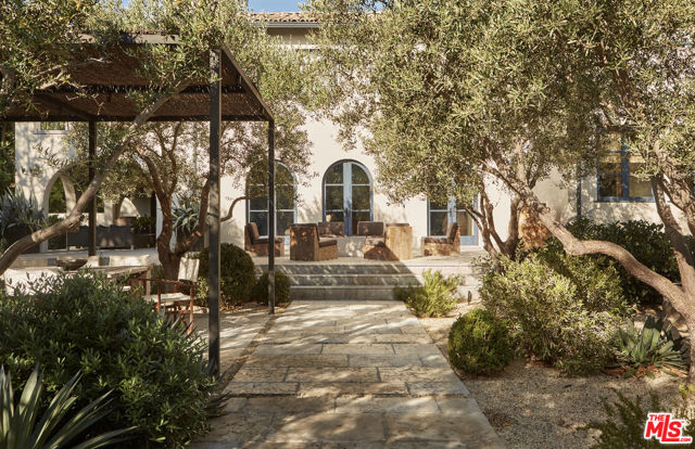 324 S June Street Los Angeles, California This impeccably designed 5 bed, 4.5 bath 1920s Mediterranean masterpiece, located on one of Hancock Parks most coveted streets, is a rare and special find. While honoring its architectural integrity, this landmark property, sited in a grove of mature olive trees, and featuring four fireplaces, has been fully updated to reflect a modern, chic sensibility. The magnificent foyer, with antique honed European marble flooring, leads to formal living and dining rooms, each with reclaimed herringbone French oak floors. Upstairs, find two generously sized bedrooms with a Jack and Jill bath, as well as another large bedroom with an ensuite bath. The primary suite, with a pitched ceiling and reclaimed wood beams, offers a gas burning fireplace, two ample walk-in closets, double vanities, and a soaking tub, as well as a terrace overlooking the exceptionally private backyard. A completely renovated gourmet kitchen features custom cabinetry, honed limestone countertops, and top-of-the-line appliances. French doors open to the perfectly landscaped garden and iron vegetable planters, just outside the kitchen doors. A beautifully appointed family room offers two sets of French doors that lead to separate outdoor patios, one covered with a fireplace, and the other offering a built-in fire pit and seating for eight. Once outside, you feel transported to another world. The Scott Shrader-designed garden offers 20k feet of pure magic. A dramatic outdoor kitchen with a covered dining area makes for intimate entertaining no matter the party size. The gated, cobbled limestone driveway leads to a porte-cochere, a two-car garage, and an updated guest house which is currently used as a pool house, featuring a spa-like steam room and a flexible bonus space overlooking the extraordinary private pool and yard. In the heart of the city, yet a world away, this home is truly one of a kind.