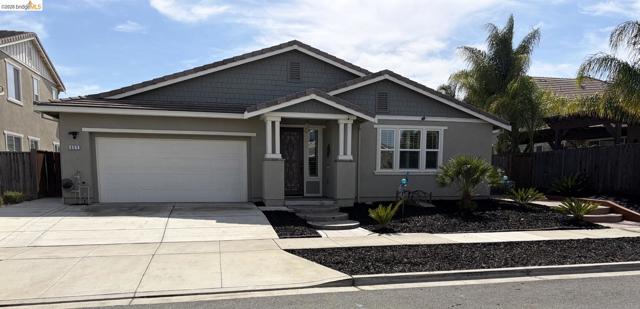 Contemporary stucco exterior with shake-style siding accents, an attached garage, a covered entry, and a multi-pane window