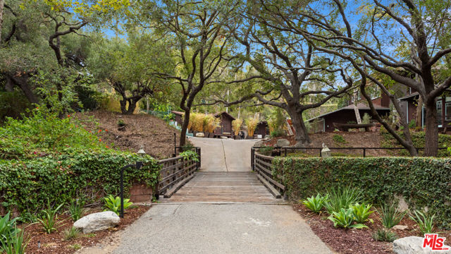 14203 W Evans Road Boulevard Pacific Palisades, California This magical, roughly 1-3/4 acre property is located on Evans Road a private, country lane bounded on one side by Will Rogers Historic Park (and its famous polo field) and Rustic Canyon Creek (a year-round waterway with natural waterfalls which runs to the Pacific Ocean) on the other. The meandering one-half mile lane, dotted with bridges criss-crossing the creek to the 16 homes located on it, has long been a little-known community, home to globally-known politicians, actors, and industry leaders. Zoned for horses, it's common to see one trotting down the lane and up the trail to the Park and the miles of equestrian and hiking trails beyond. An abundance of towering Sycamores, Eucalyptus and Oak trees conveys a park-like quality and ensures the ultimate in privacy. Maintain the charming remodeled 4,100+ SF, 5-bedroom home, complete with pool and N/S facing tennis court, or design the estate compound of your dreams. Crest Real Estate Report and preliminary programming and design by world-renowned architects Woods + Dangaran are available.