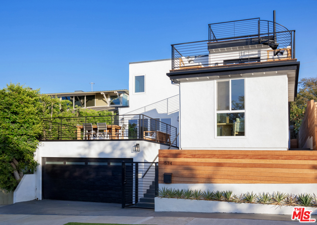 574 Mount Holyoke Avenue Pacific Palisades, California This exquisitely renovated home situated on the gorgeous Palisades bluffs is the perfect Southern California retreat. Boasting 4 bedrooms, 4.5 bathrooms, plus a studio guest house with a full kitchen and bathroom, this home comfortably fits a large or small family. With an open floor plan providing a seamless indoor-outdoor flow to multiple sun-soaked decks, this luxury property is ideal for entertaining. The master suite, encompassing the entire second floor, features dual vanities, soaking tub, two walk-in closets, a fireplace, and direct access to the expansive deck to catch the sunset creating the ultimate oasis. Relax and enjoy 360 degree views of the ocean, mountains, and canyons along the stunning California coastline from the rooftop deck or one of the many terraces around the house. No detail was spared in the meticulous remodel of this trophy house. All just moments away from Palisades Village offering the best shopping, restaurants, and parks LA has to offer.