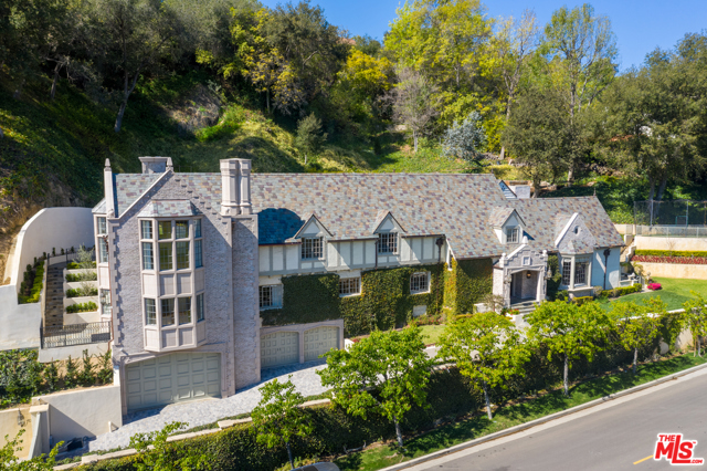 10950 Bellagio Road Los Angeles, California Prominently located in prestigious Lower Bel Air Estates sits this gorgeous English Manor on a generous acre lot privately gated & perched above the fairway of one of the world's most exclusive country clubs. Surrounded by pristine landscaping, soaring trees & dead-on golf course views, this elegant estate is bound to steal your heart. A gated entry greets you to the sweeping motor court for your most prized car collection. Entertain in the formal living room w/voluminous vaulted ceilings, opulent fireplace & oversized windows allowing for floods of natural light. A chef's dream, the kitchen is equipped w/La Cornue range, eat-in island, extensive cabinetry, elegant tile details & opens to the bright dining room with French doors to the outdoor oasis. The serene master suite in a private wing boasts a decadent marble spa-like bath, boutique worthy walk-in closet & private balcony w/fireplace overlooking the captivating vistas. Enjoy the California weather in the Resort-style yard with tranquil waterfall leading into the dazzling pool. Amenities include well-appointed guest suites, multiple living spaces for entertaining or work from-home-living, wine cellar, elevator & much more. A true gem in a world-class locale w/unparalleled views. Do not miss the opportunity to capture your dream home in highly coveted Bel Air/Beverly Hills area!