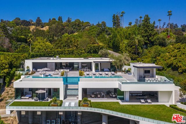 1251 Tower Grove Drive Beverly Hills, California Visionary owners joined forces with acclaimed architect Paul McClean and interior designer Lynda Murray to build this one-of-a-kind estate as featured in Le Chat, Modern Luxury & Vie magazines. Brand-new construction set in Beverly Hills on over an acre of land. Notably McClean's finest work to date. Minutes from the Beverly Hills Hotel, Rodeo Dr. & world-renowned entertainment. Every facet is perfectly crafted, culmination of the rarest, most unique materials & finishes worldwide with top-of-the-line appliances & amenities. Enjoy barrierless indoor/outdoor living & jetliner views from Century City to the Pacific Ocean. The estate includes a luxurious master suite, office, guest wing, home theater, gym, game room, BBQ, fire pit, lounge, spa & two pools connected by a never-before-seen transparent water bridge. Imbued with style & sophistication, rarely does an estate of this caliber come to market. Live the life you've always dreamed of in the most sought-after zip code in the world.