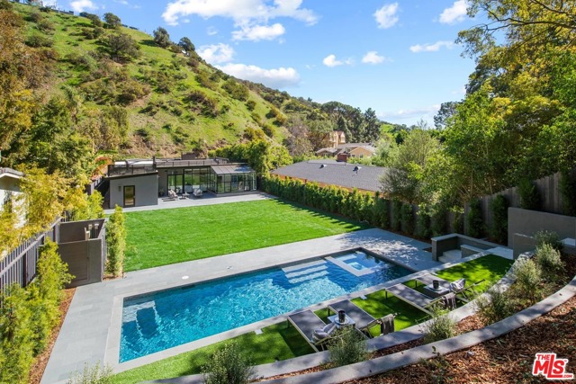 1833 Franklin Canyon Drive Beverly Hills, California Sited in Prime Lower BHPO, moments to Franklin Cyn Park/Coldwater Cyn Park, this 3 BD/3 BA, recently/tastefully updated Mid-Century Modern, graces a mostly flat, double lot affording the utmost in privacy and seclusion. Casual, open floorplan w/ an abundance of natural light. Formal foyer opens to a voluminous living area w/ soaring ceilings/fireplace/floor-to-ceiling bookcase/walls of glass, dramatically taking in the sweep of the backyard, one of the largest/most special in the area. Sun-rm, perfect as an entertaining space/or peaceful sanctuary. The kitchen is large, open/features stainless steel appliances/breakfast area. All 3 BDs ensuite, primary BD w/ direct orientation to the backyd, large walk-in closet/spa-like BA feat. soaking tub/over-sized shower/dual vanities/sauna. The backyd is uncommonly grand w/ spectacular cyn views. Multiple areas for alfresco entertaining, a vast grassy area/lounging deck/new pool/spa. Off-st parking. Warner Elementary.