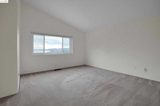 Spare room featuring lofted ceiling and light colored carpet