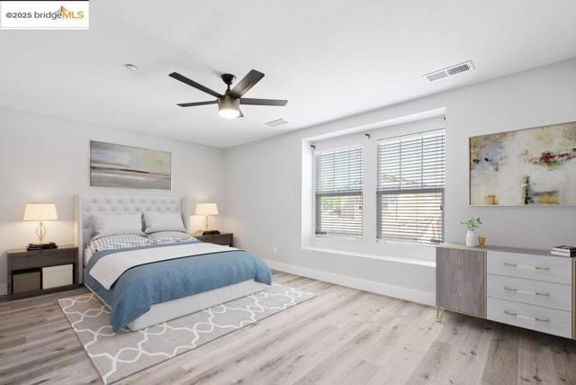 Bedroom with light wood-style flooring and a ceiling fan