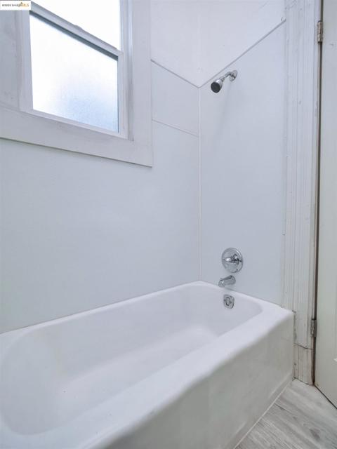 Bathroom featuring bathing tub / shower combination and wood finished floors