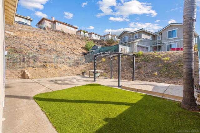 Nice yard with turf and room for a patio, built in bbq area custom seating and easy access to the sliding glass doors into the kitchen area!