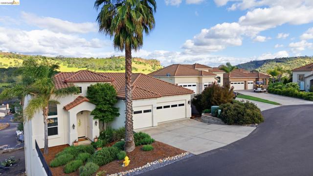 Mediterranean / spanish-style house featuring stucco siding, concrete driveway, a garage, and a tiled roof