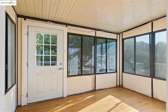 Unfurnished sunroom with wood finished floors
