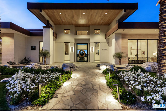 Custom built in 2019, this designer finished contemporary masterpiece, tucked away at the end of a private cul-de-sac in the exclusive double gated Muirfield estates at Mission Hills, expresses the pinnacle of design. The four bedroom, four and a half bath plus office home on .61 acre lot, boasts towering double story ceilings throughout, an architecturally inspired light flooded hallway and a graciously embellished tongue and groove portico/loggia with a wall of glass that folds away to allow the indoor and outdoor spaces to live as one. The outdoor spaces, replete with custom stone entry, breathtaking landscaping, captivating mountain and fairway views, custom pool, spa, fire pit, serve up bar, covered outdoor kitchen and outdoor shower are sure to impress. The home's custom architecture offers art gallery-like hallways for displaying art, custom lighting, two primary suites with expansive spa inspired bathrooms, soaking tubs and large walk-in closets each adjacent to their own separate two car garages and laundry spaces. The home also features two additional graciously appointed en-suite guest retreats. The breathtaking home office is sure to delight with a floor to ceiling glass slider and two outdoor patios. The luxurious gourmet kitchen, flanked by a custom wet bar and a well outfitted caterer's kitchen with additional double oven is outfitted with custom countertops, champagne brass fixtures, top of the line European appliances, 3 double door dishwashers and affords plenty of storage in the ample custom cabinetry. The formal dining room opens up to the outdoor space to entice guests to enjoy the beauty that surrounds. This marvel is integral to the Mission Hills Country Club and allows close proximity to all the amenities, championship golf, tennis and pickle ball and so much more offered through the club. Furnishings are available for purchase outside of escrow.