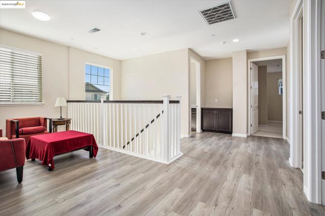 Living area with an upstairs landing, light wood-type flooring, and recessed lighting