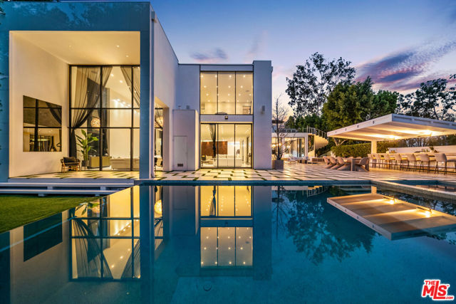 Set behind gates on one of the most prestigious streets in Beverly Hills, this iconic estate by noted architect William S. Beckett is nothing short of a masterpiece. Fully reimagined in 2015, the home showcases grand-scale living spaces, soaring ceilings, and exquisite finishes, with floor-to-ceiling walls of glass revealing far-reaching views. Among its impressive features are a staggering chef's kitchen, walk-in wine cellar, state-of-the-art theatre, Gym, Hair Salon, Massage room, Candy wall, Crestron system, Attached guesthouse, and 6-car auto gallery. Architectural staircases lead to the second level with a voluminous master boasting dual showroom closets and private terrace with spa overlooking views of Beverly Hills. Lush grounds include tiled patios, a meditation garden, bar and grill, ample lawns and zero-edge infinity pool. Set on nearly an acre, this unprecedented estate is minutes from the best of Beverly Hills while offering a level of space and privacy that firmly establishes it among the city's prized residences.