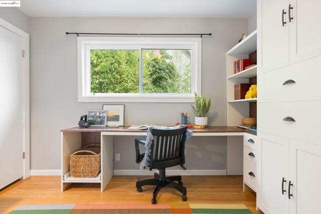 Office area with built in study area and light wood-style flooring