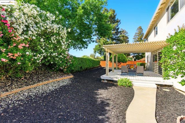 Fenced backyard with a pergola and a deck
