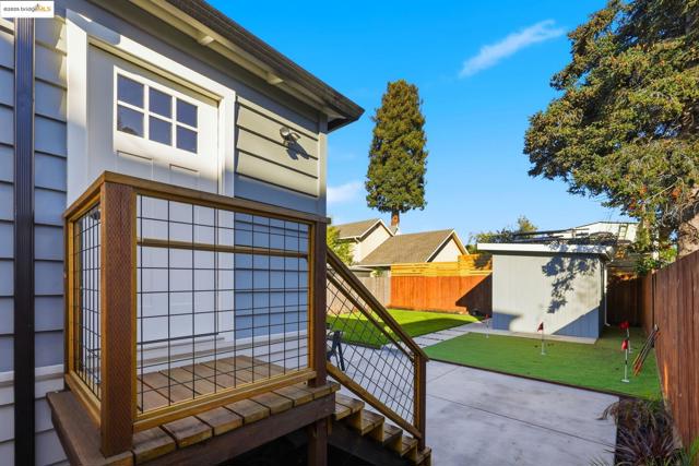View of side of home featuring a patio, an outbuilding, and a fenced backyard
