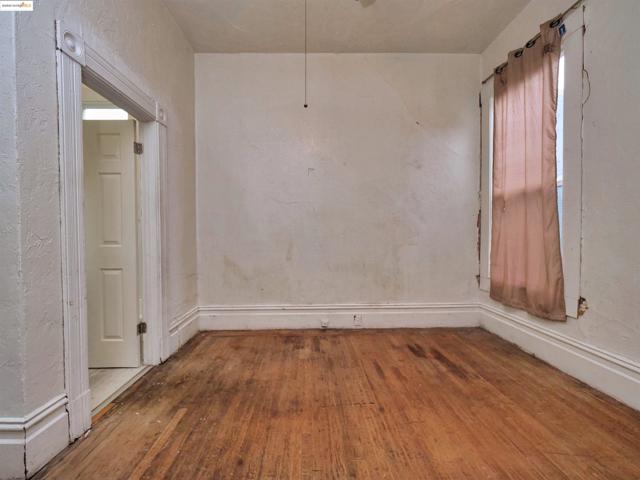 Empty room with hardwood / wood-style flooring and a textured wall
