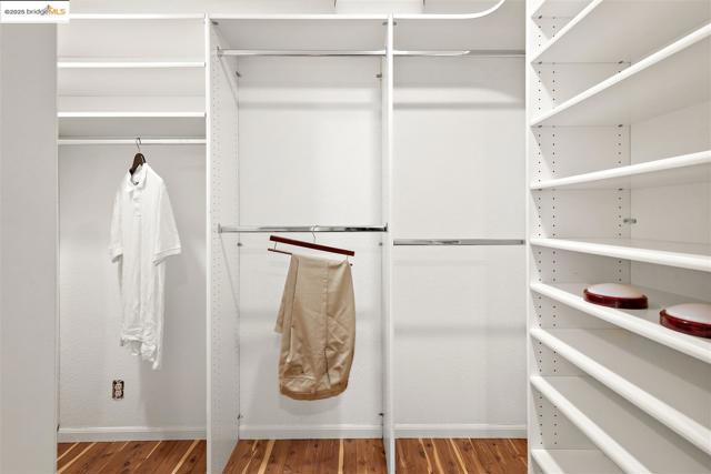 Walk in closet with wood finished floors