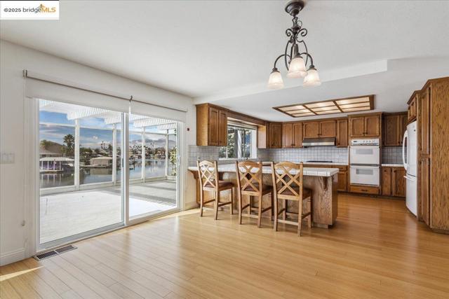 Kitchen featuring light countertops, backsplash, a kitchen bar, and light wood-style flooring