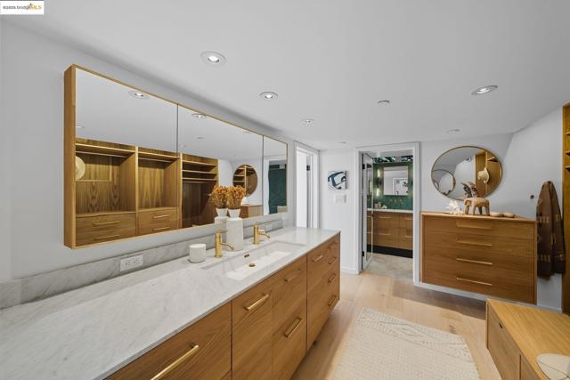Bathroom featuring vanity, light wood finished floors, recessed lighting, a spacious closet, and a shower stall