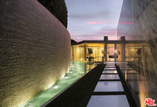 1814 N Doheny Drive Los Angeles, California Situated in the Doheny Estates above the famous Sunset Strip, this contemporary masterpiece captures sweeping city to ocean views. A sophisticated, entertainer's retreat, the 5-bedroom home seamlessly integrates indoor and outdoor living while showcasing masterful, modern detail. Floor-to-ceiling glass walls surround the living areas, while gallery-sized walls accommodate an extensive art collection. The great room boasts a floor-to-ceiling marble fireplace and opens to the magnificent view terrace, 119' pool & spa. The exquisite kitchen features a separate butler's pantry and expansive breakfast bar, while the formal dining room overlooks the cascading water feature and temperature-controlled wine storage. Home features include a spectacular poolside master suite, office-library, lower-level living room, bar, fitness studio & plush home theater. An architectural marvel, this ultra-private retreat is situated moments from the Sunset Strip's acclaimed dining, shopping & entertainment.