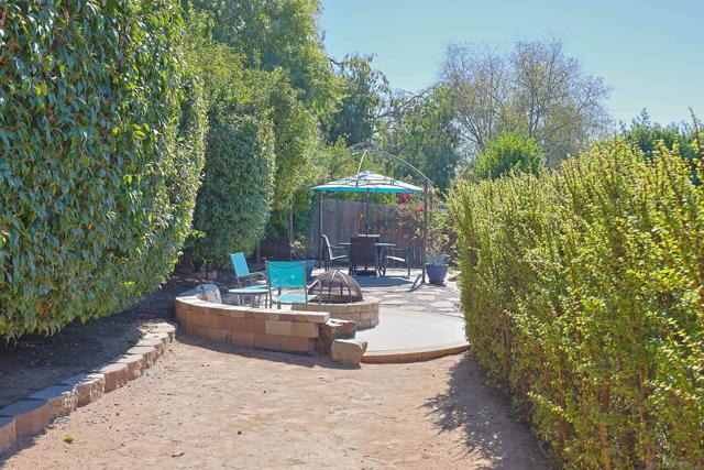 The tiered backyard space features an inviting outdoor firepit and dining area, perfect for entertaining guests. Plus, there's potential for an Additional Dwelling Unit (ADU) to suit your future needs.