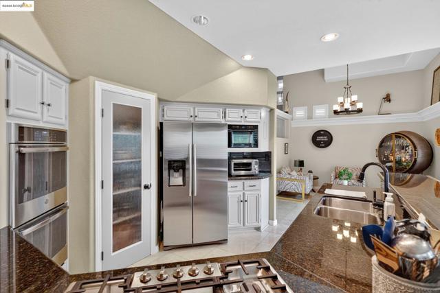 Kitchen featuring appliances with stainless steel finishes, pendant lighting, white cabinetry, light tile patterned flooring, and recessed lighting